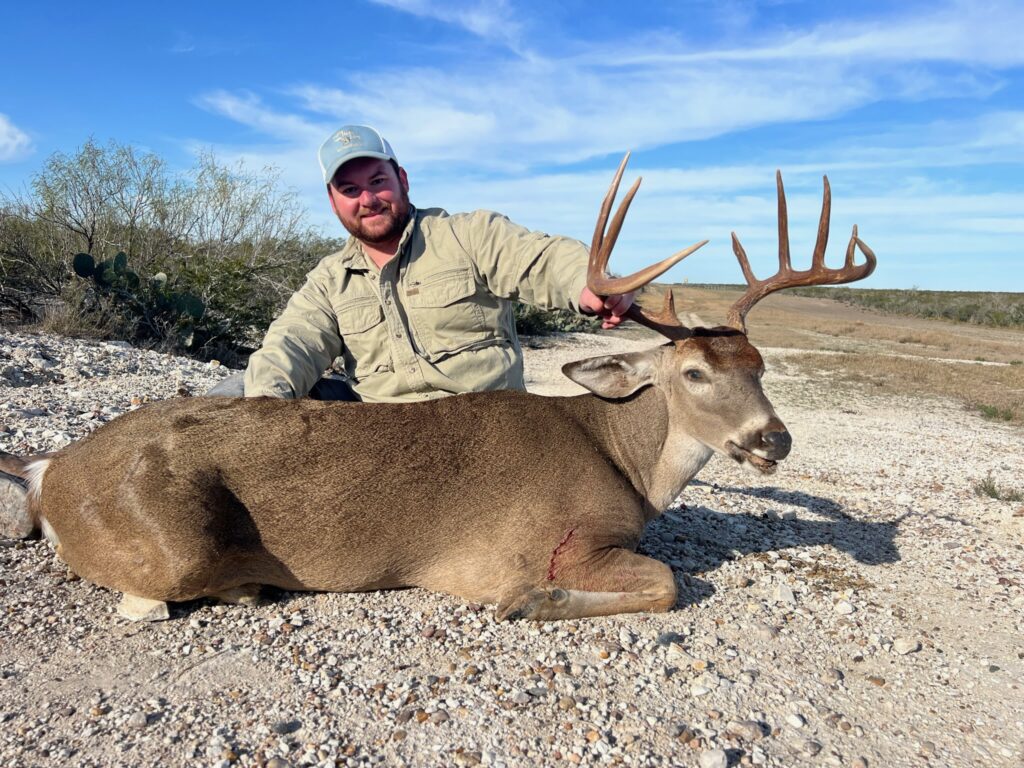 Hunter posing with a large deer he successfully hunted.