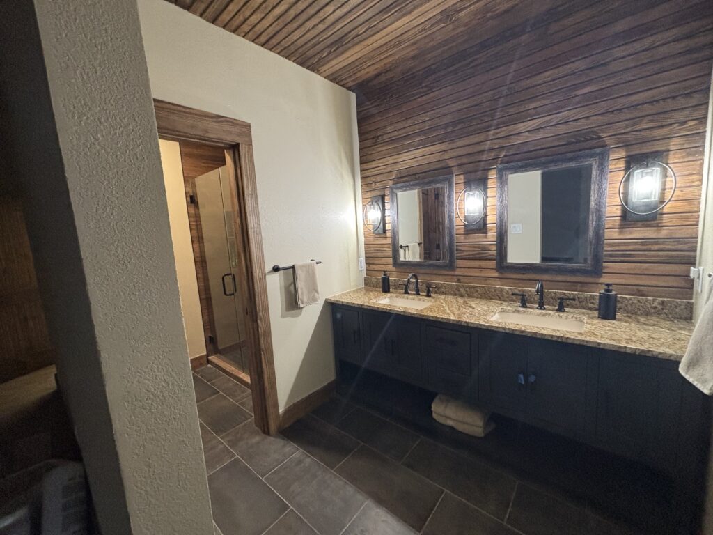 Modern bathroom with wooden ceiling and double sink vanity.