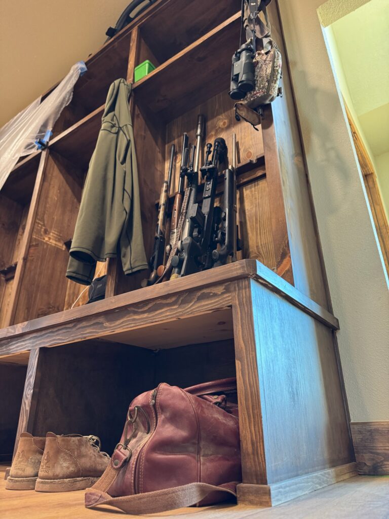 Rustic wooden shelf with vintage tools and a jacket hanging above.